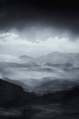 Wall Mural - mysterious dark landscape with hills and mountains shrouded in fog