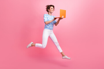 Wall Mural - Full length profile photo of overjoyed person jump use wireless laptop coworking isolated on pink color background