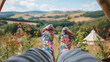 relaxing feet in colorful floral socks against a scenic camping background