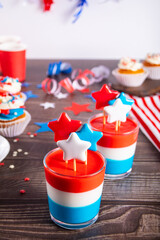 Independence Day Fourth of July USA American patriotic party with american symbols. Glasses of tasty dessert layered colorful jelly with star hard rock caramel