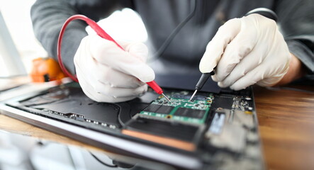 Canvas Print - Close-up of male professional working with instruments and tools. Technician wearing protective gloves fixing personal computer circuit board. Gadgets support and maintenance