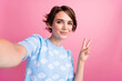 © deagreez - Portrait of pretty positive lady make selfie arm fingers demonstrate v-sign isolated on pink color background