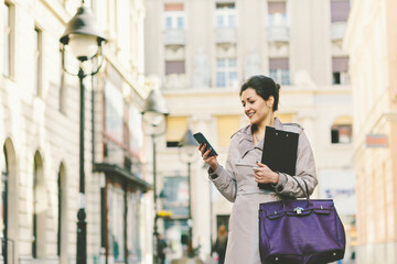 Young businesswoman in the city using smart phone