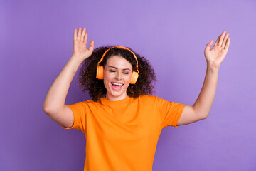 Wall Mural - Photo of funky carefree lady dressed orange t-shirt having fun enjoying music headphones isolated violet color background