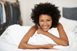 Black woman, portrait and in bed with smile for relax, wellness and self care after sleep in house. Female person, happy and peace with duvet for morning wake up, health and stress therapy on weekend