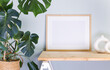 Stylish room interior with mockup photo frame on the wooden shelf with house plant