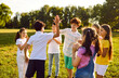 © Studio Romantic - Group of a happy kids having fun and giving each other high five when they meet while walking in the summer park in nature. Cheerful children friends laughing outdoors. Friendship concept.
