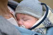 Extreme close up of a baby sleeping in a baby carrier, in an extraordinary closeness to his mother