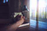 Fototapeta  - hands praying to god on bible on a wooden table in the morning. Pray for god blessing to wish to have a better life and life to be out of the crisis. begging for forgiveness and believing in goodness.