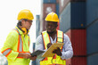 © DG PhotoStock - Container yard workers examine the container cargo.