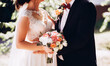 Groom and bride with bouquet during wedding ceremony. Close up