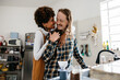 Affectionate couple making their morning coffee together in kitchen