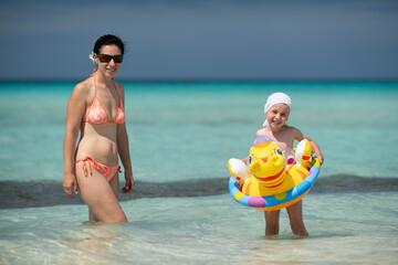 girl bathes in the ocean, swim with an inflatable toy, inflatable ring, Atlantic ocean, Cuba, Caribbean sea, summer vacation, summer weekend, maternity leave