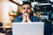 © BullRun - Portrait of young worried hipster guy looking at camera sitting at laptop computer waiting for exams results,male freelancer puzzled on solutions concentrated on completing task in coworking office