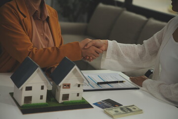 Discussion with a real estate agent, House model with agent and customer discussing for the contract to buy, get insurance or loan real estate or property.