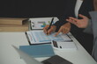 © Sirikarn Rinruesee - Team of business people working together in the meeting room office, teamwork background charts and graphs banner, double exposure successful teamwork,business planning concept.