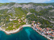 AERIAL: Scenic shot of a small beachfront settlement on a Croatian island Hvar