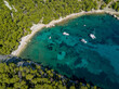 AERIAL: Scenic shot of couple of boats anchored in a peaceful bay of Hvar island