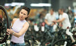 Adult woman buyer chooses bicycle in sports store