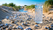 A glass of water is sitting on a beach with rocks around it