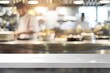 empty white table, blurred background chef cooking in restaurant kitchen