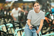Young woman in modern bicycle shop choosing new sport bike and selecting model seat