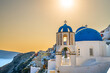 Blue bell domes of Oia village on Santorini island at sunset. Greece