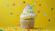 Birthday cupcake with confetti on yellow background. Colorful confetti on cupcake