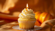 Tasty yellow cupcake with candle isolated orange background