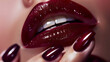 The image showcases a close-up of a person’s lips and nails, both adorned in a matching glossy burgundy shade