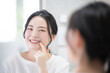 © kapinon - Cute woman looking at her teeth and whiteness while looking in the mirror Whitening, etc. Close-up