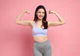 Fototapeta Panele - Happy young woman with slim body showing her muscles on pink background