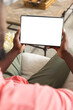 African American man relaxing at home, holding blank tablet screen with copy space