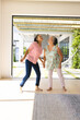 © Wavebreak Media - Asian grandmother and biracial teenage granddaughter dancing at home