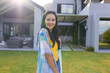 © Wavebreak Media - Biracial young woman standing outdoors in front of house