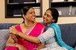© Wavebreak Media - Indian mother and teenage daughter, sitting close, laughing together