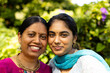 © Wavebreak Media - Indian mother and teenage daughter smiling together in garden