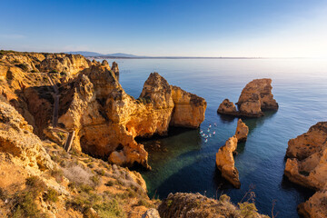 Wall Mural - Panoramic view, Ponta da Piedade near Lagos in Algarve, Portugal. Cliff rocks and tourist boat on sea at Ponta da Piedade, Algarve region, Portugal. Ponta da Piedade, Algarve region, Portugal.