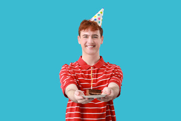 Poster - Young man with piece of birthday cake on blue background