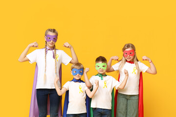 Sticker - Group of kids in superhero costumes with yellow ribbons on color background. International Childhood Cancer Day