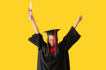 Wall Mural - Cheerful female graduate diploma on yellow background