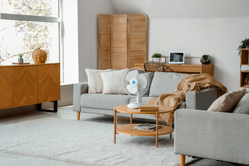 Poster - Interior of light living room with modern electric fan on coffee table