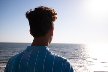 A young attractive guy is walking on the beach.