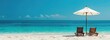 © Doni_Art - two chairs on the edge of the beach in front of the blue ocean, with a bright blue sky.