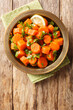 Traditional Moroccan carrot salad with cilantro, warm spices, light dressing of lemon juice and olive oil closeup on the plate on the table. Vertical top view from above