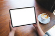 © Farknot Architect - Top view mockup image of a woman holding digital tablet with blank white desktop screen in cafe