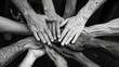 © Rattanathip - Black and white photo of many hands of different colors and ages coming together.