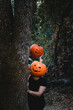 Two friends wearing carved Halloween pumpkin heads with scary faces