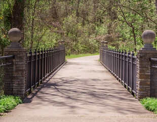 Wall Mural - A concrete pathway with iron railings over a creek