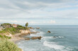 Cliffside homes overlook a tranquil, rocky coastline